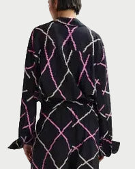 Person wearing a black outfit with pink and white pattern on a white background