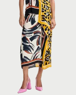 Woman wearing a colorful dress with a pattern of leaves and a yellow border on a white background