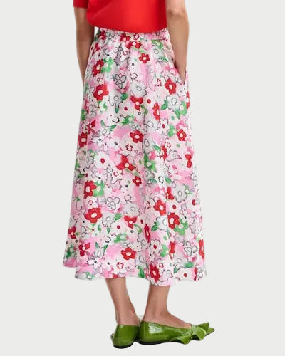 Person wearing a red top and floral skirt on a white background