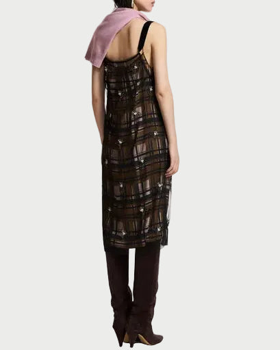 A model is shown from the back wearing a sheer black and brown plaid midi dress with a pink scarf draped over one shoulder and dark brown over-the-knee boots, set against a plain white studio background.
