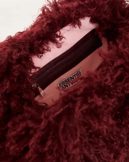Interior of an Essentiel Antwerp Katerin Faux Fur Bag showing a deep red faux fur exterior, a light pink lining, and a zippered pocket.
