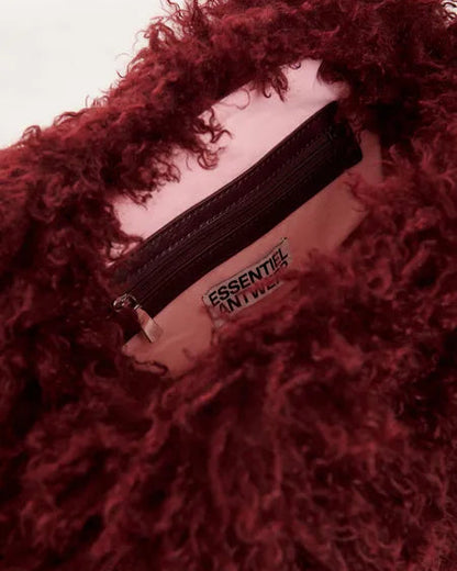 Interior of an Essentiel Antwerp Katerin Faux Fur Bag showing a deep red faux fur exterior, a light pink lining, and a zippered pocket.