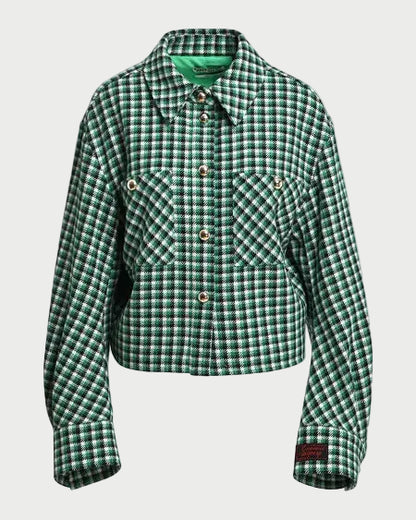 A green and black checkered cropped jacket with a pointed collar, button front, and two chest pockets, displayed on a neutral light gray background.