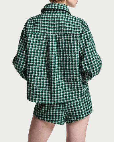 A model shown from the back wearing a green and white plaid button-up shirt and matching shorts against a plain light gray background.