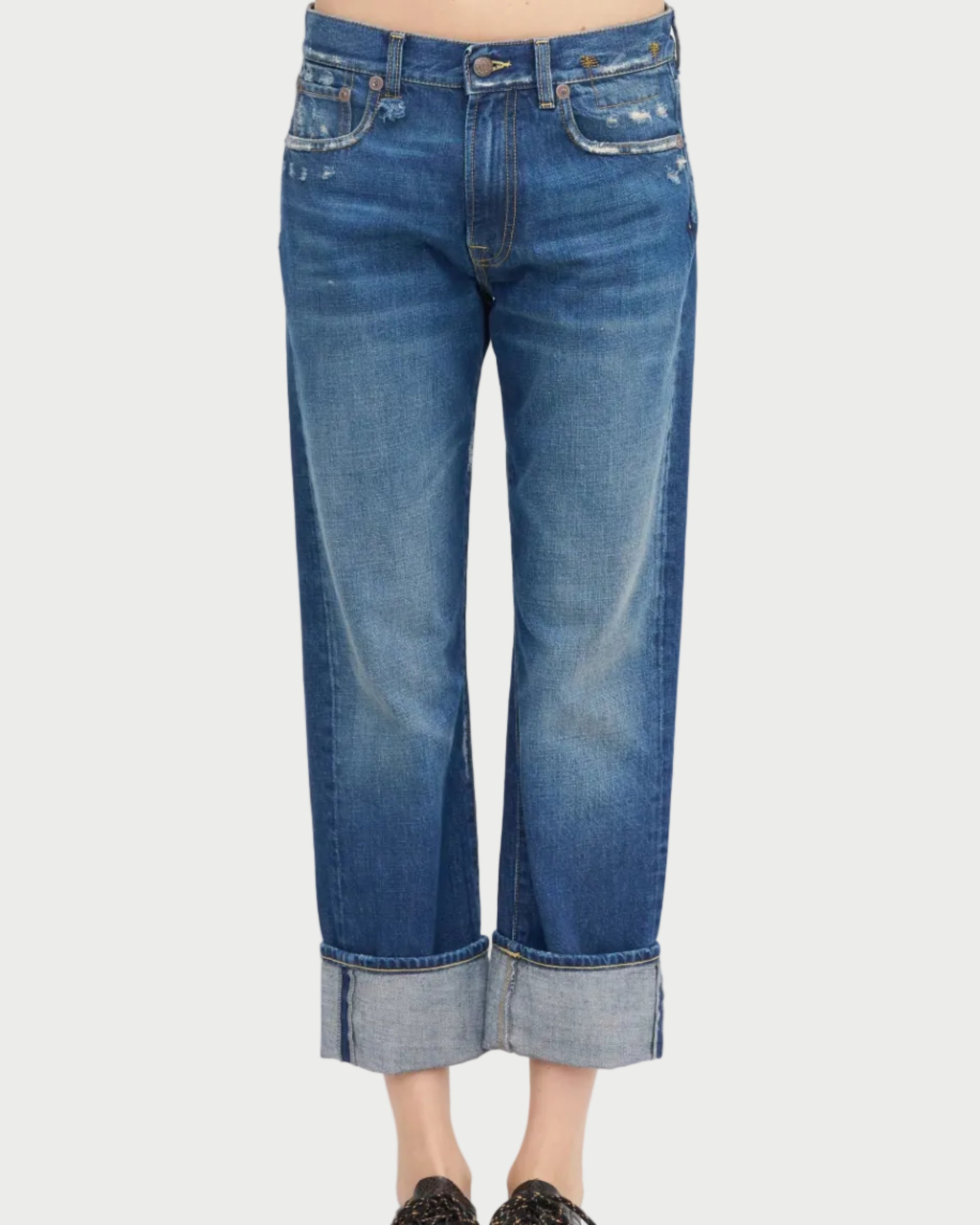 A person wearing R13 Cuffed Romeo Jean Oasis Blue—slim boyfriend fit, lightly distressed Italian denim—stands against a white background.