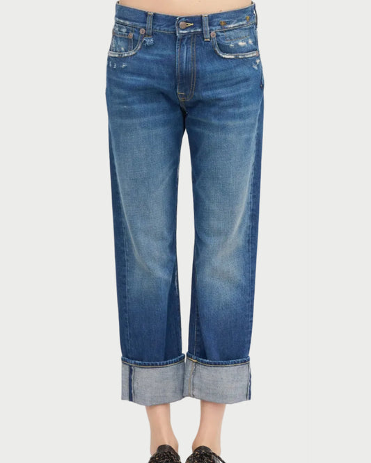 A person wearing R13 Cuffed Romeo Jean Oasis Blue—slim boyfriend fit, lightly distressed Italian denim—stands against a white background.