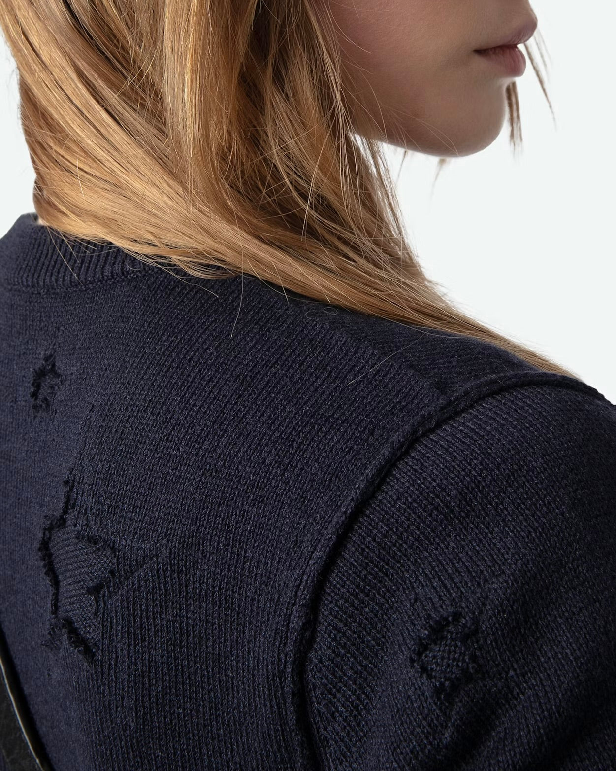 A person is seen wearing the Short Sleeve Stars Sweater by Zadig & Voltaire. Their light brown hair falls beautifully over their shoulder, and their face is partially turned away from the camera against a plain backdrop.