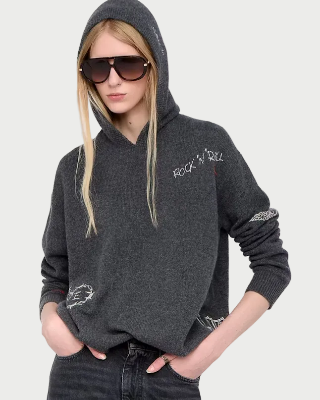 Person wearing a dark gray hoodie and black jeans on a white background