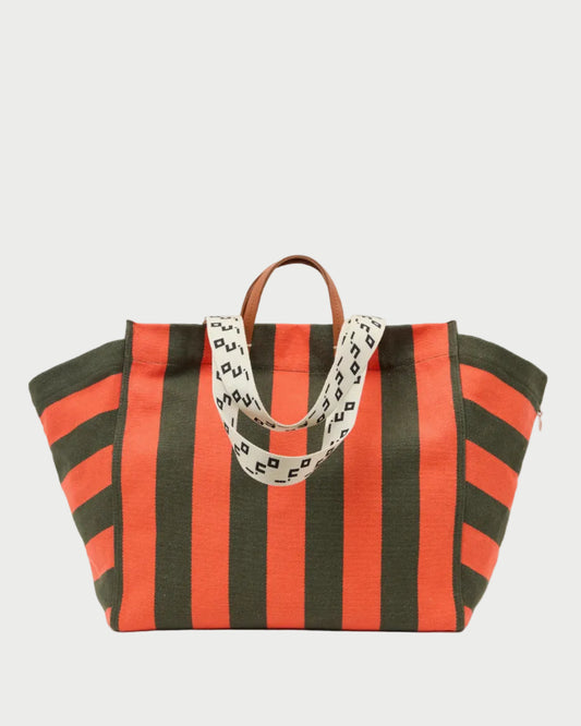 A striped canvas tote bag with alternating orange and dark green vertical stripes, featuring a patterned cream shoulder strap and brown leather top handles, shown against a plain white background.