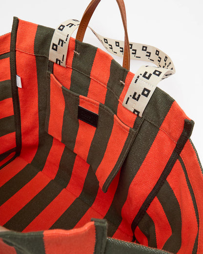 Red and black striped bag with a patterned strap on a white background