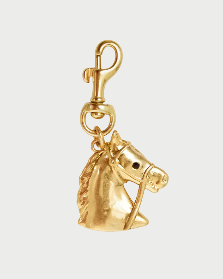 Gold horse head charm on a white background