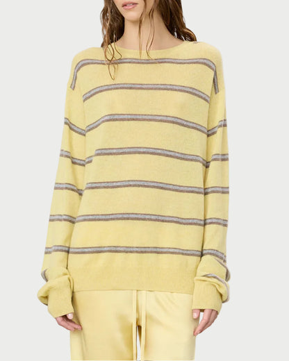 Woman wearing a yellow and gray striped sweater on a white background