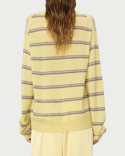 Person wearing a yellow striped sweater on a plain background