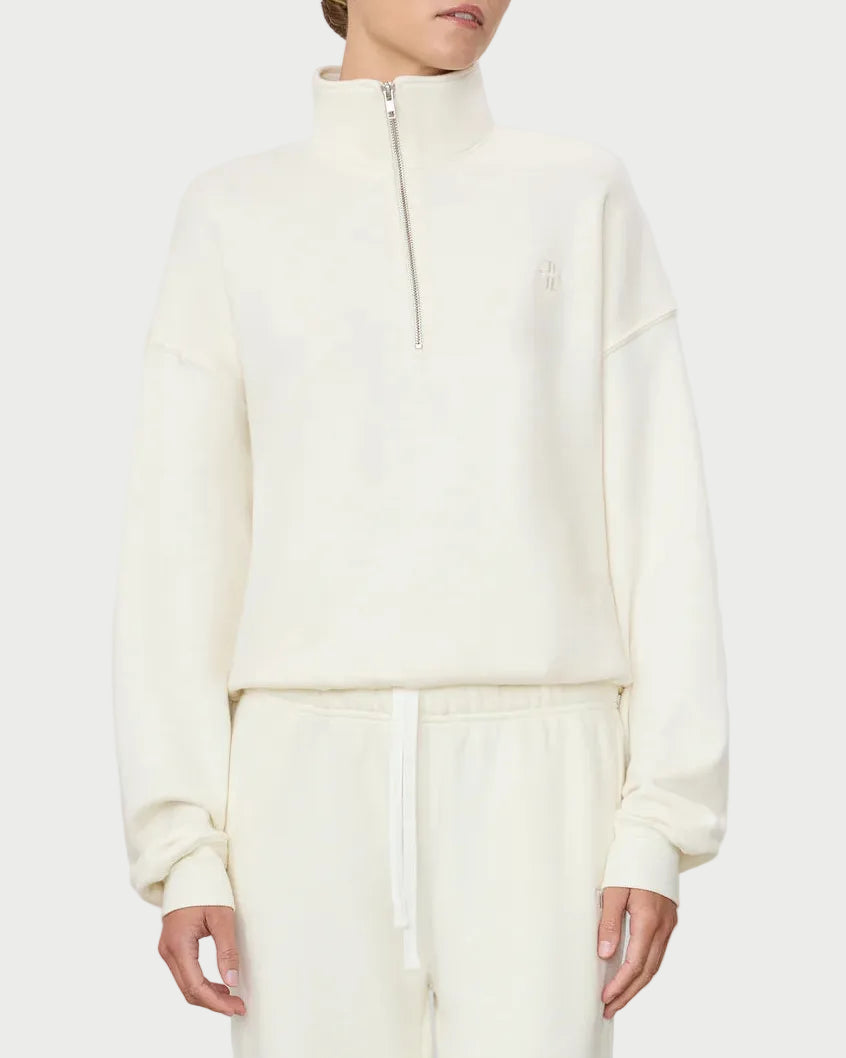 Woman wearing a white zip-up hoodie and pants on a light gray background