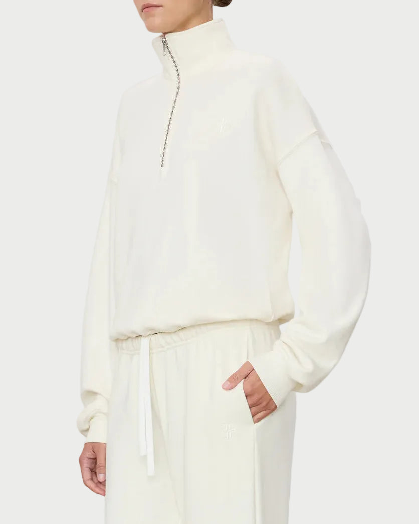 Woman wearing a white outfit against a plain background