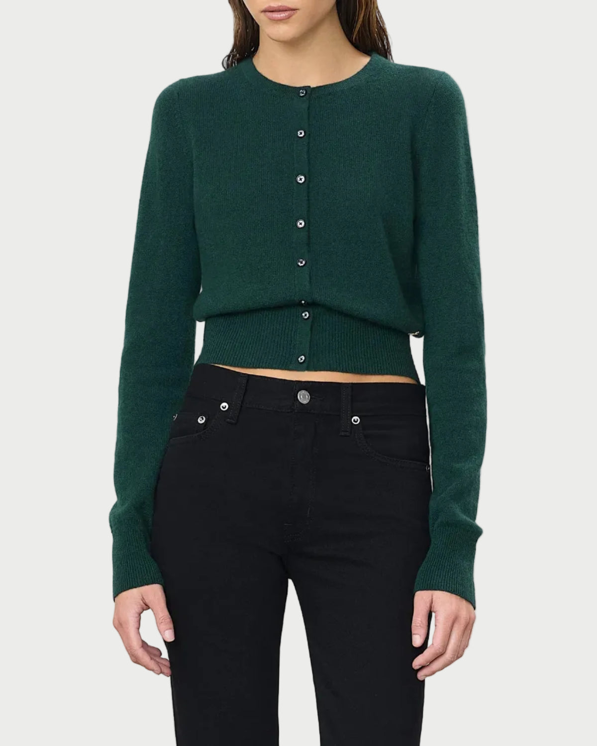 A person wearing the Éterne Reese Cashmere Sweater by Eterne, styled with high-waisted black jeans, stands against a plain white background.