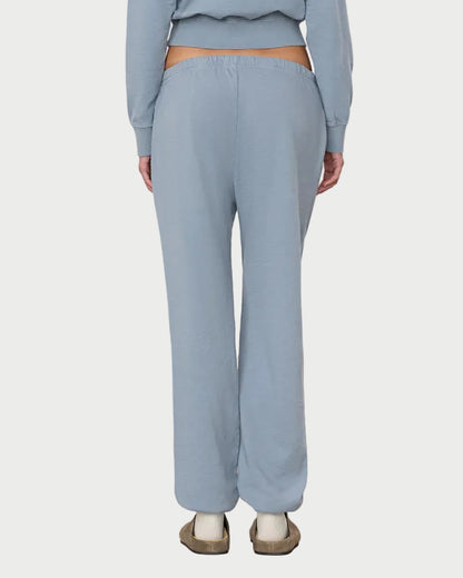 Person wearing a light blue outfit standing against a white background