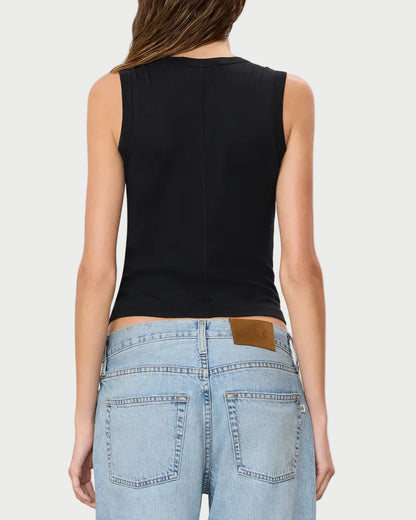 A person is shown from behind, wearing the Éterne Fitted Muscle Tank by Eterne in black, paired with light blue high-waisted jeans featuring visible back pockets and a brown patch on the waistband; only the upper body and lower back are visible.