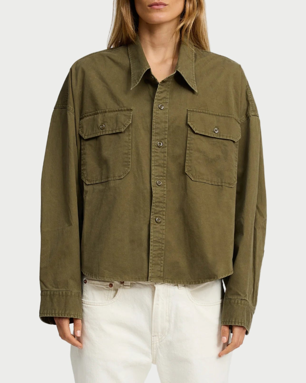 Woman wearing an olive green jacket on a white background