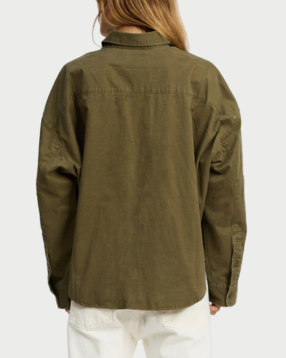 Person wearing an olive green jacket on a white background