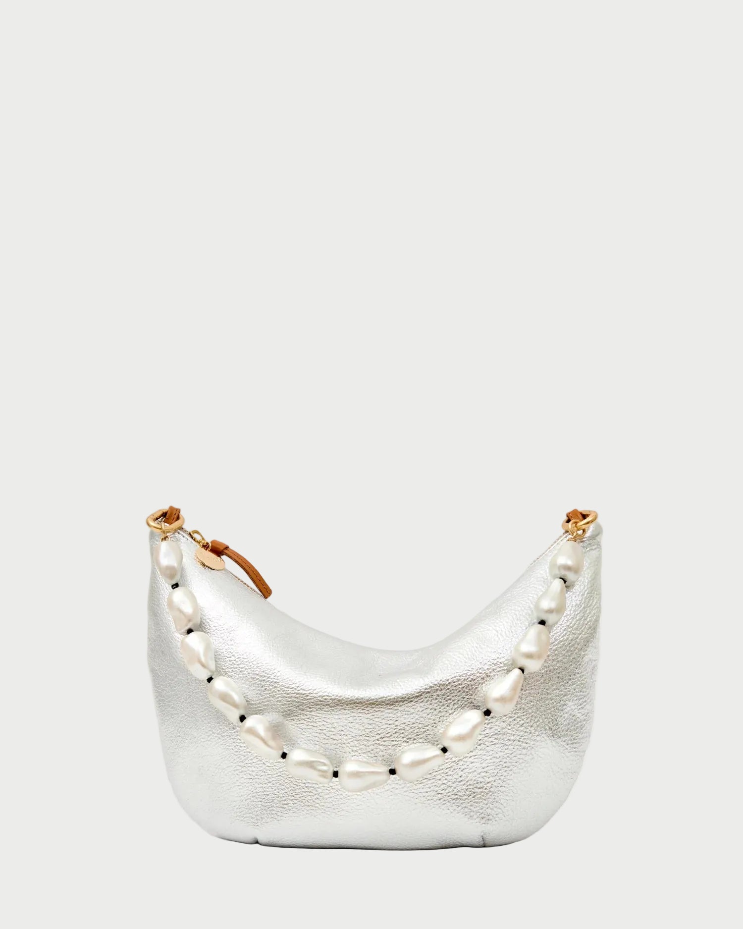 A small, metallic silver handbag with a brown zipper pull, adorned with the CLARE V. Shortie Strap In Pearl—large, irregular pearls draped elegantly across the front.