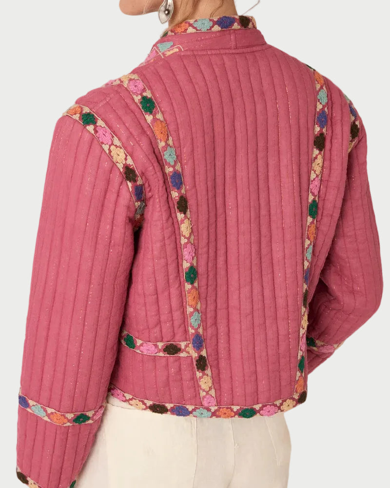 Pink jacket with colorful embroidery on a plain background