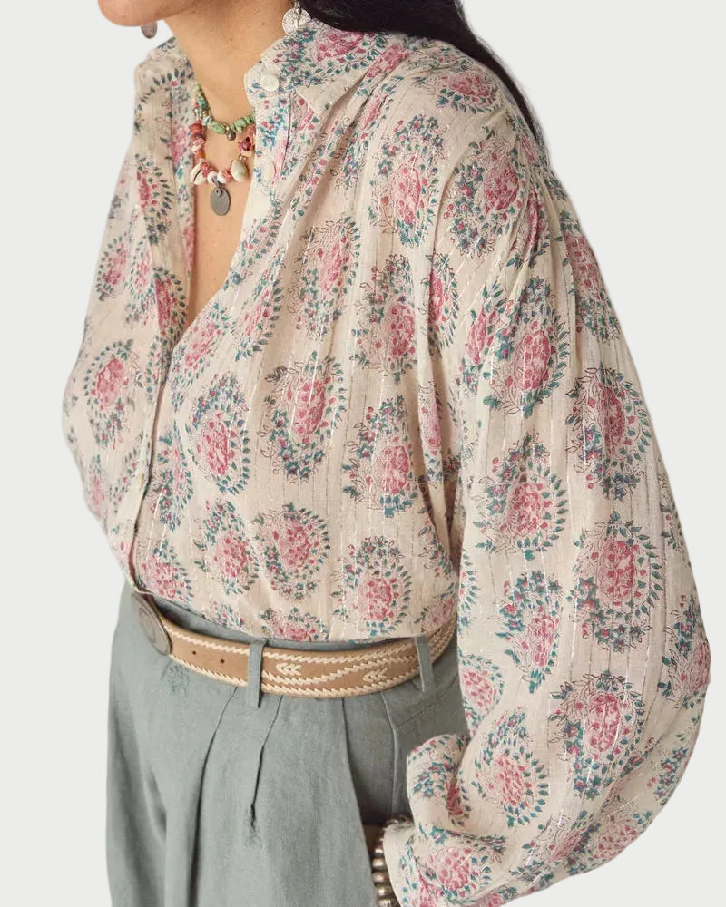 Woman wearing a floral blouse with a neutral background
