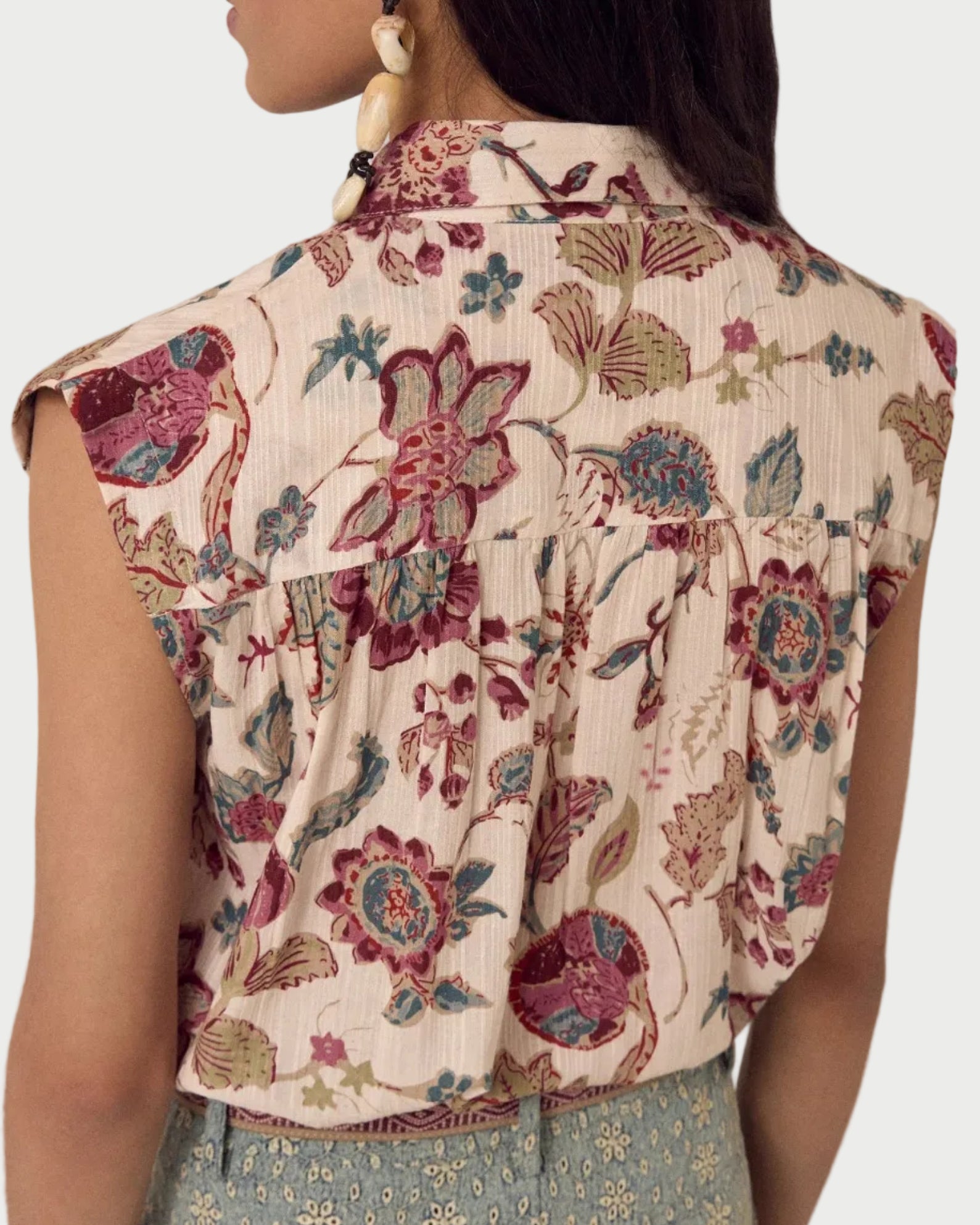 Woman wearing a floral blouse with a neutral background