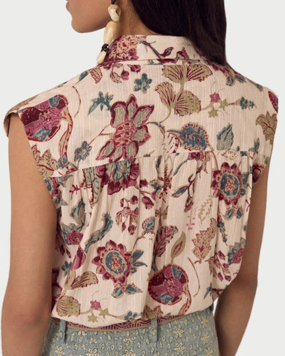 Woman wearing a floral blouse with a neutral background