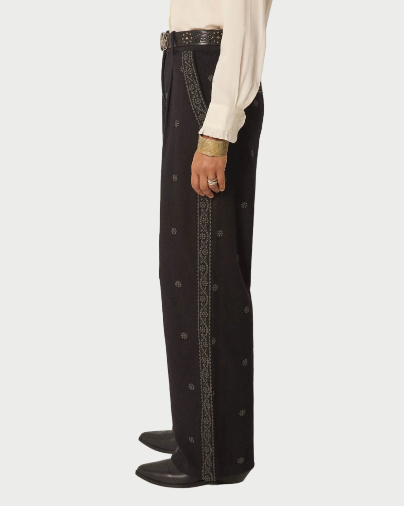 Black pants with decorative side panels worn by a person on a plain background