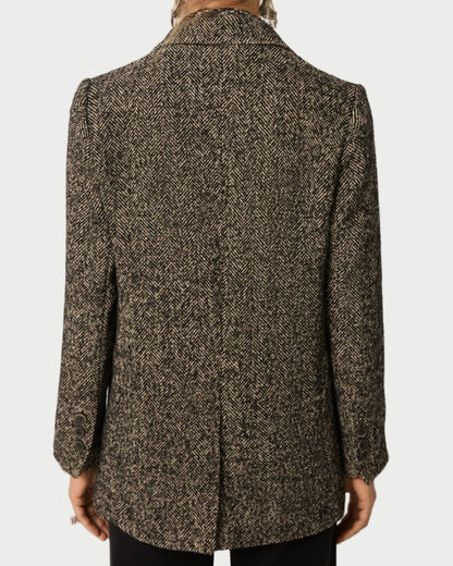 Back view of a person wearing a patterned coat on a plain background