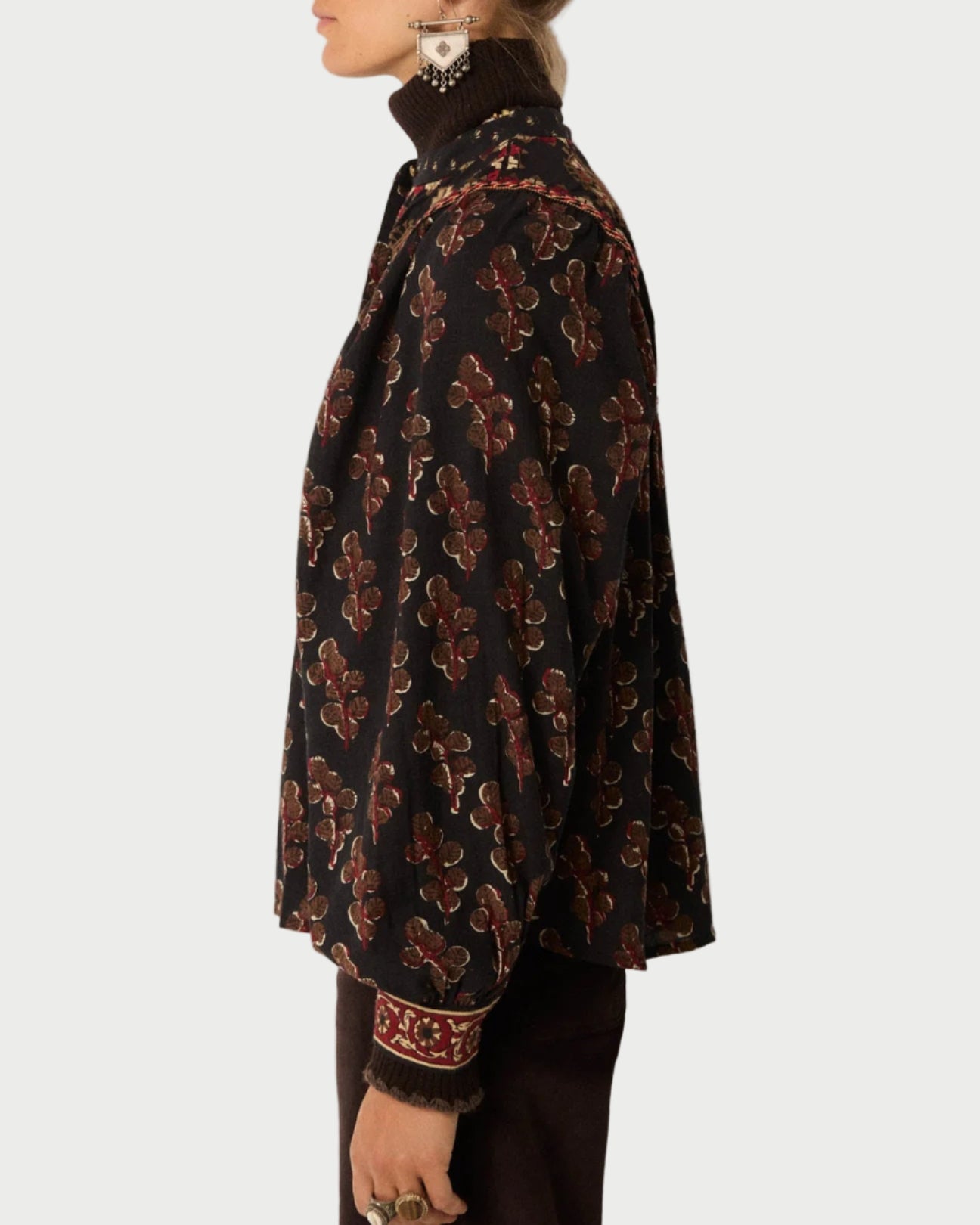 Person wearing a patterned jacket on a plain background