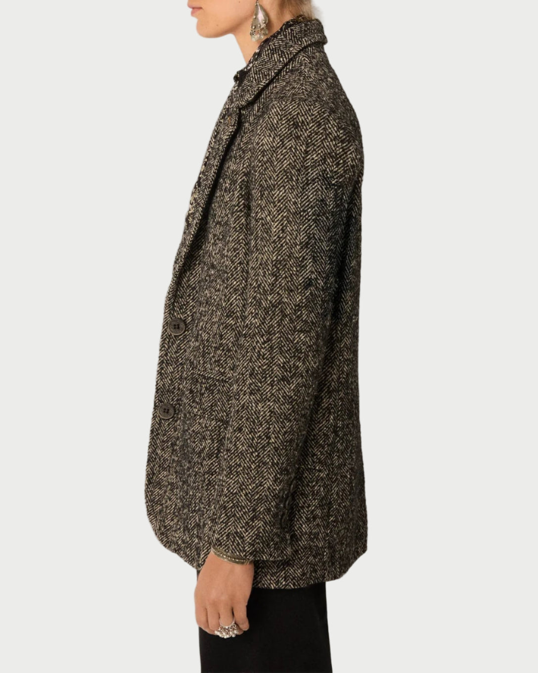 Woman wearing a textured coat against a plain background