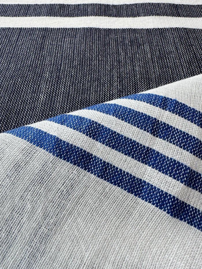 Close-up of fabric with blue and white stripes on a gray background