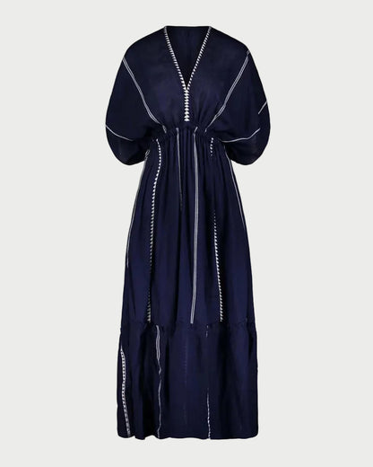 Navy blue dress with white trim on a light gray background