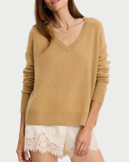 A woman wearing a tan One Grey Day Sloane Cashmere V-Neck with raglan sleeves.