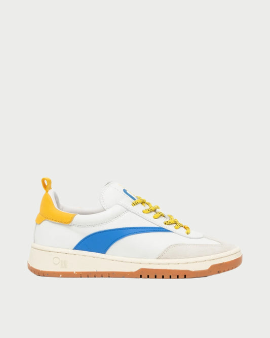 The Oncept Panama Sneaker is a stylish white shoe featuring a blue stripe, yellow heel accent, and yellow laces. Designed for comfort, it has a white sole with brown tread that adds to its simple yet sporty appearance.