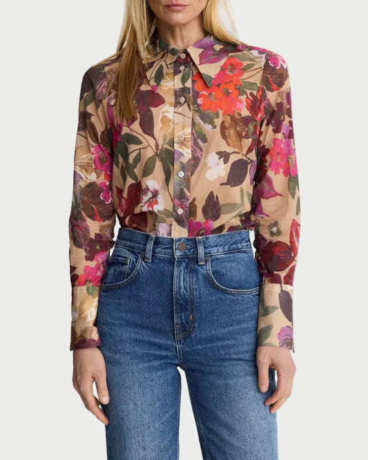 Woman wearing a floral blouse and blue jeans on a white background