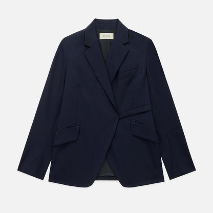 The WE-AR4 Smoking Blazer by WE-AR4 is a dark navy sustainable blazer with notch lapels, two flap pockets, a chest pocket, and a single-breasted design, crafted from upcycled virgin wool and shown laid flat on a white background.