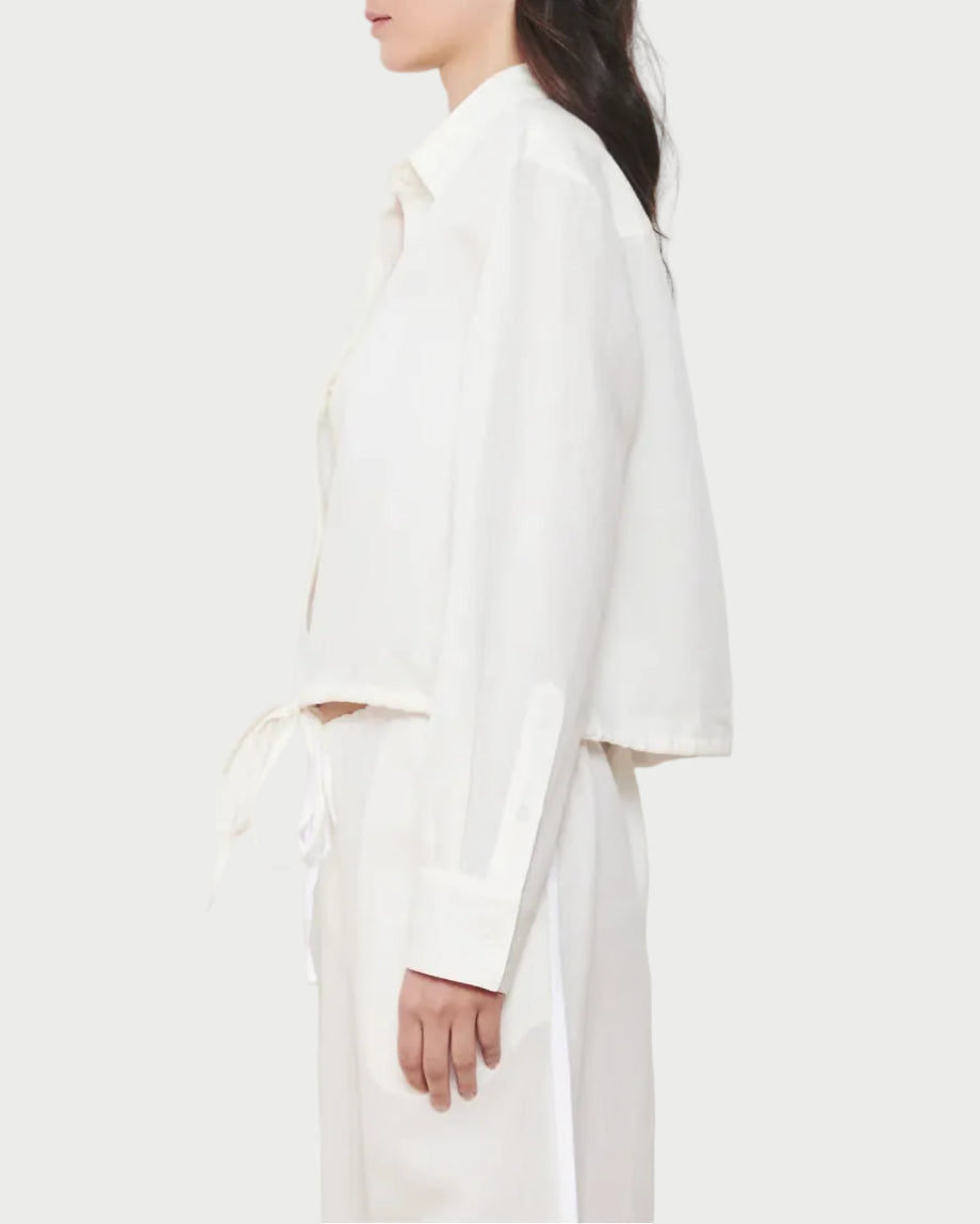 Woman wearing a white outfit against a plain background