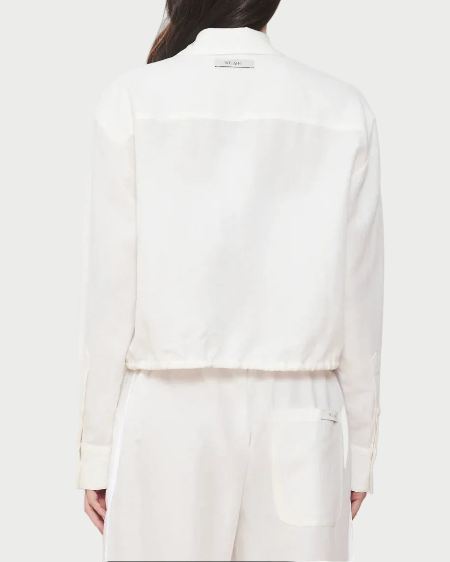 Person wearing a white suit on a plain background