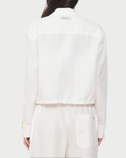 Person wearing a white suit on a plain background