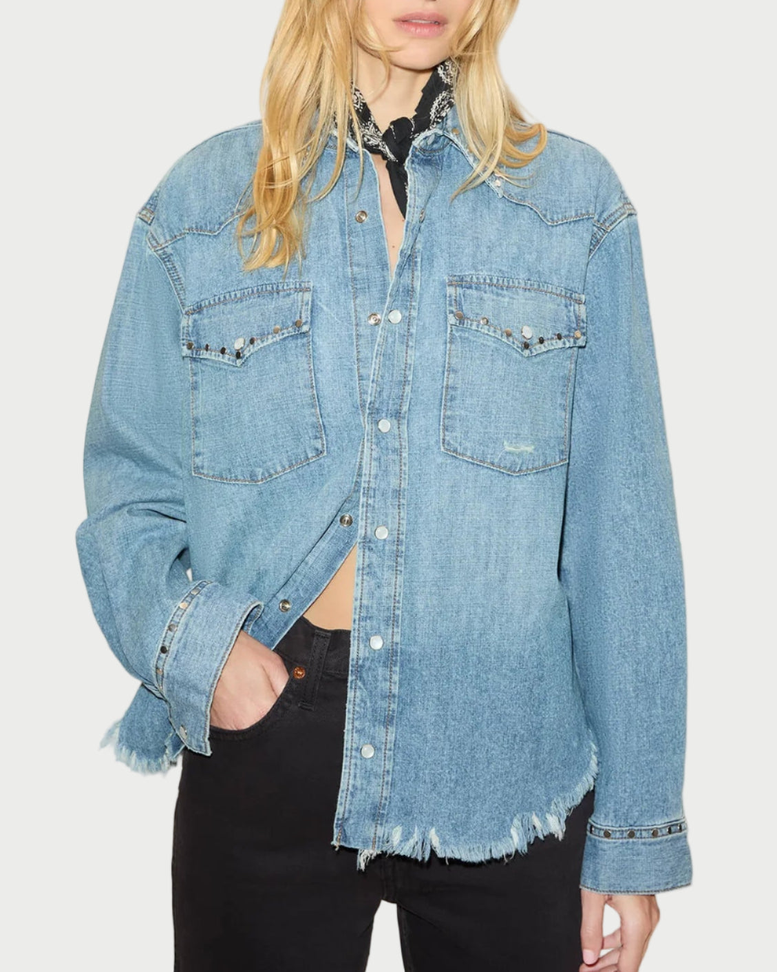 Woman wearing a light blue denim jacket against a white background