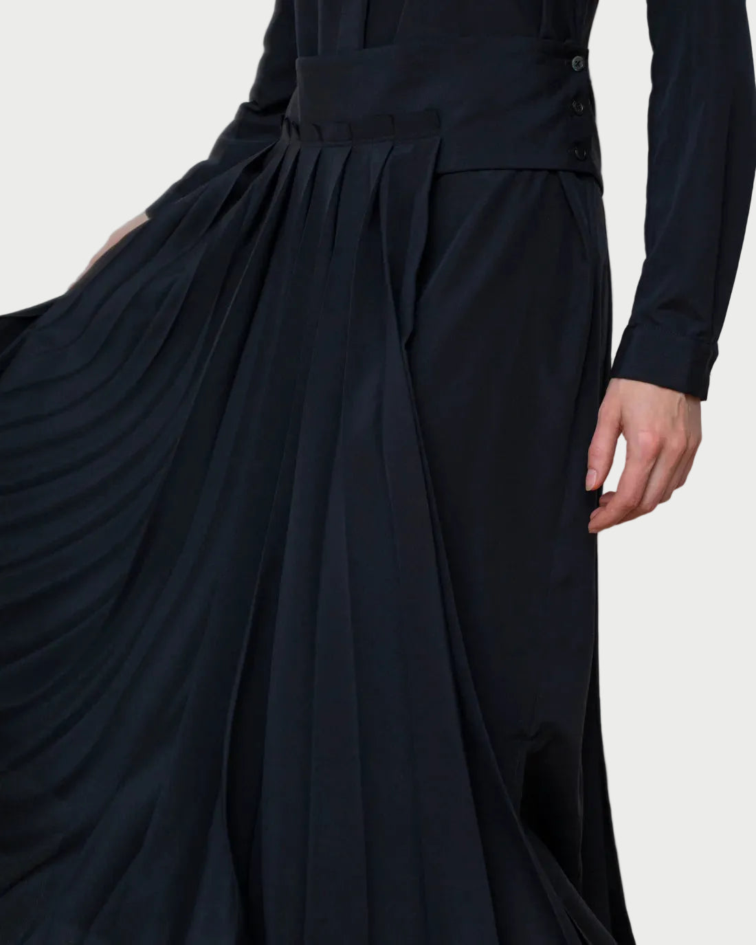 Black dress with a pleated skirt on a plain background