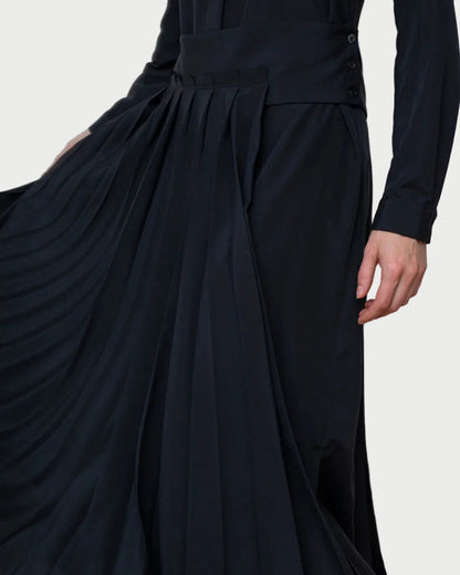 Black dress with a pleated skirt on a plain background