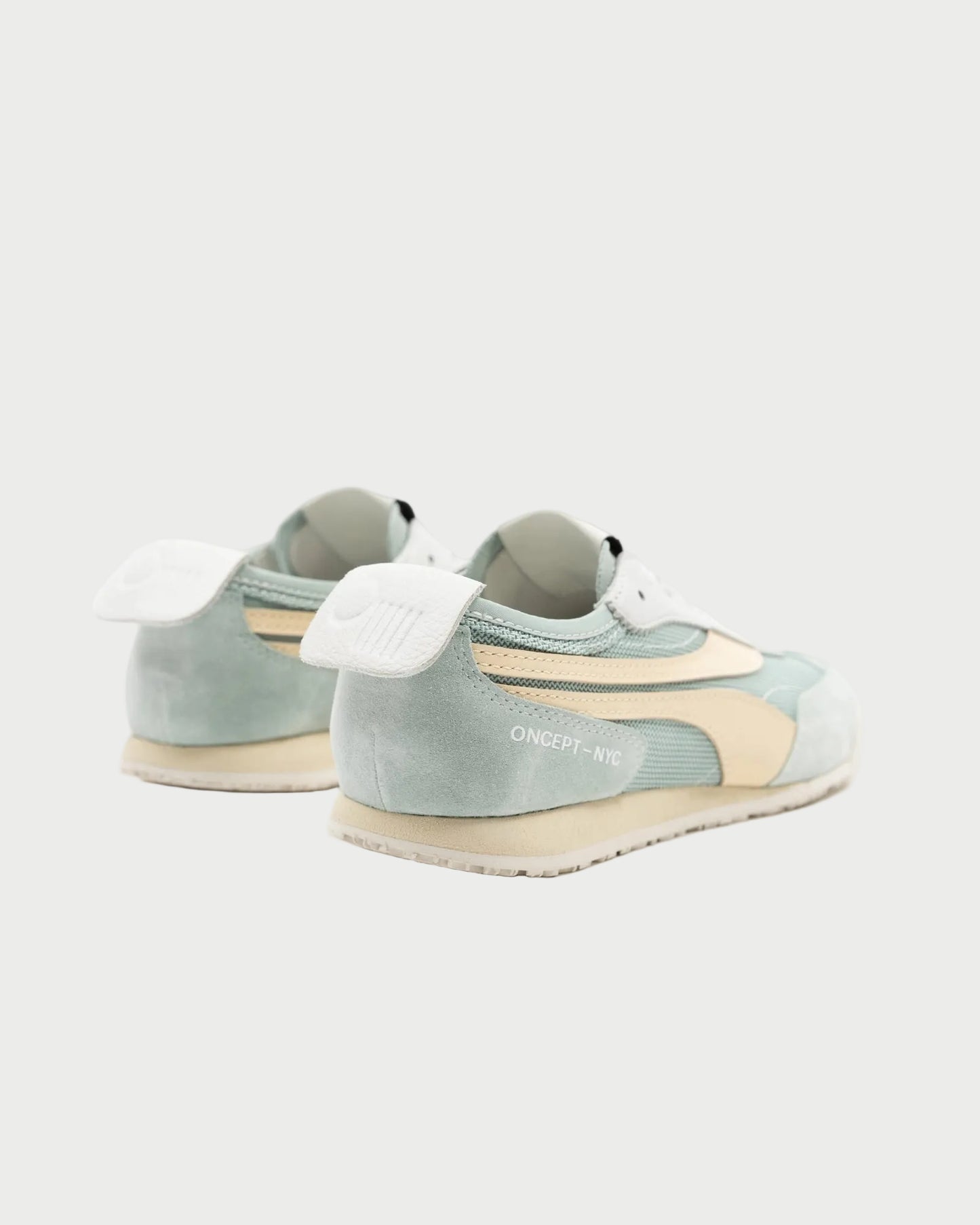 The Oncept Reno Sneaker, in pastel green and beige with white laces and soles, features "ONCEPT-NYC" branding on the side. These retro running shoes by Oncept are shown from a rear side angle against a white background.