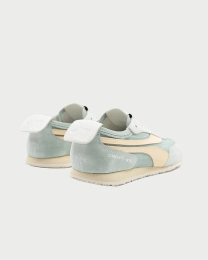 The Oncept Reno Sneaker, in pastel green and beige with white laces and soles, features "ONCEPT-NYC" branding on the side. These retro running shoes by Oncept are shown from a rear side angle against a white background.