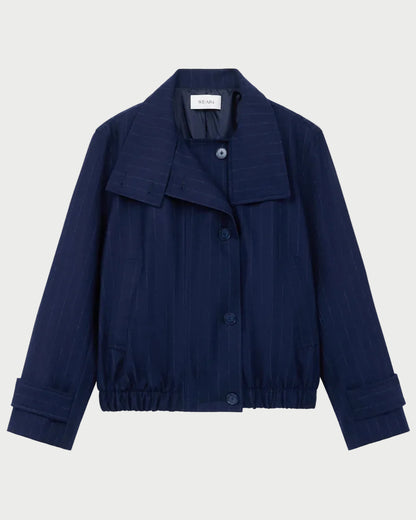 The WE-AR4 Kent Jacket by WE-AR4 is an upcycled wool, navy blue button-up with a collar, cuffed sleeves, subtle pinstripes, and elastic at the hem, shown on a plain light background.