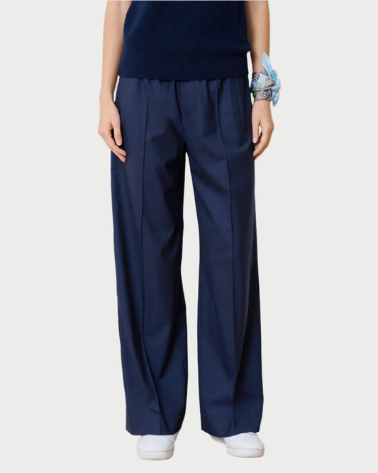 Person wearing navy blue pants and a dark top on a white background