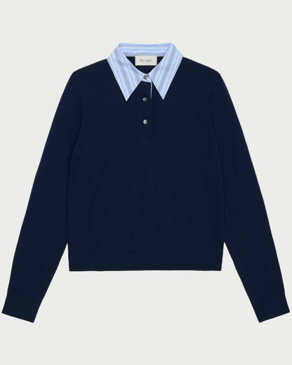 The WE-AR4 Charlie Polo by WE-AR4 is a navy knit pullover with light blue and white striped collar detail and a partial button placket, offering an effortlessly preppy layered look.